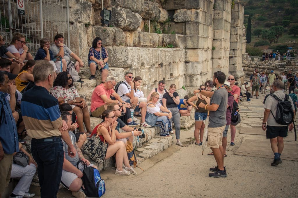 מדריך עומד מול מטיילים עם ציוד לתרגום סימולטני אלחוטי